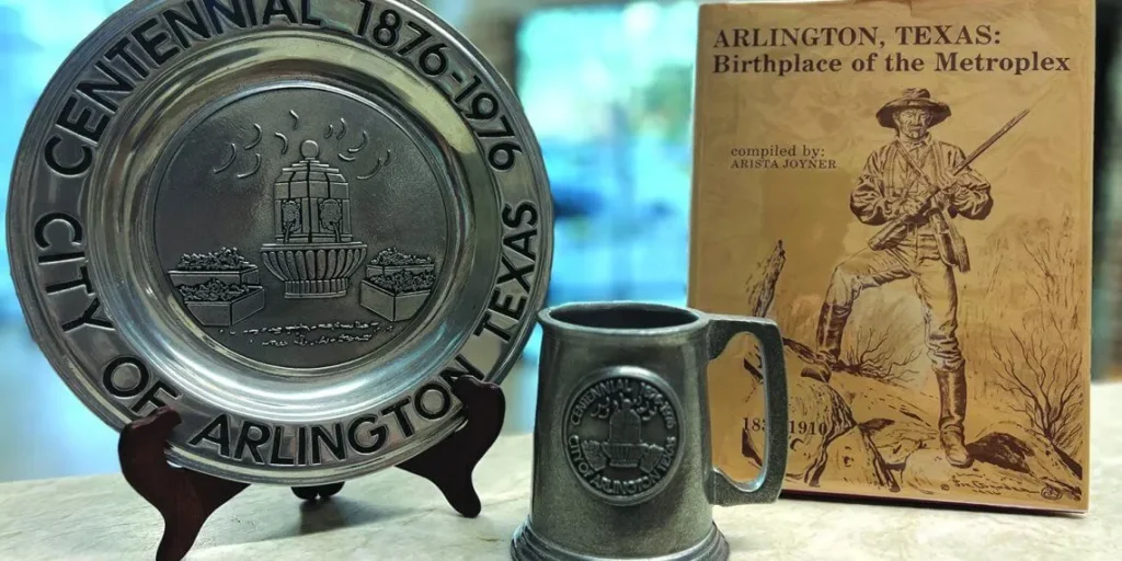 Centennial Plate, Mug and book displayed on a table. 