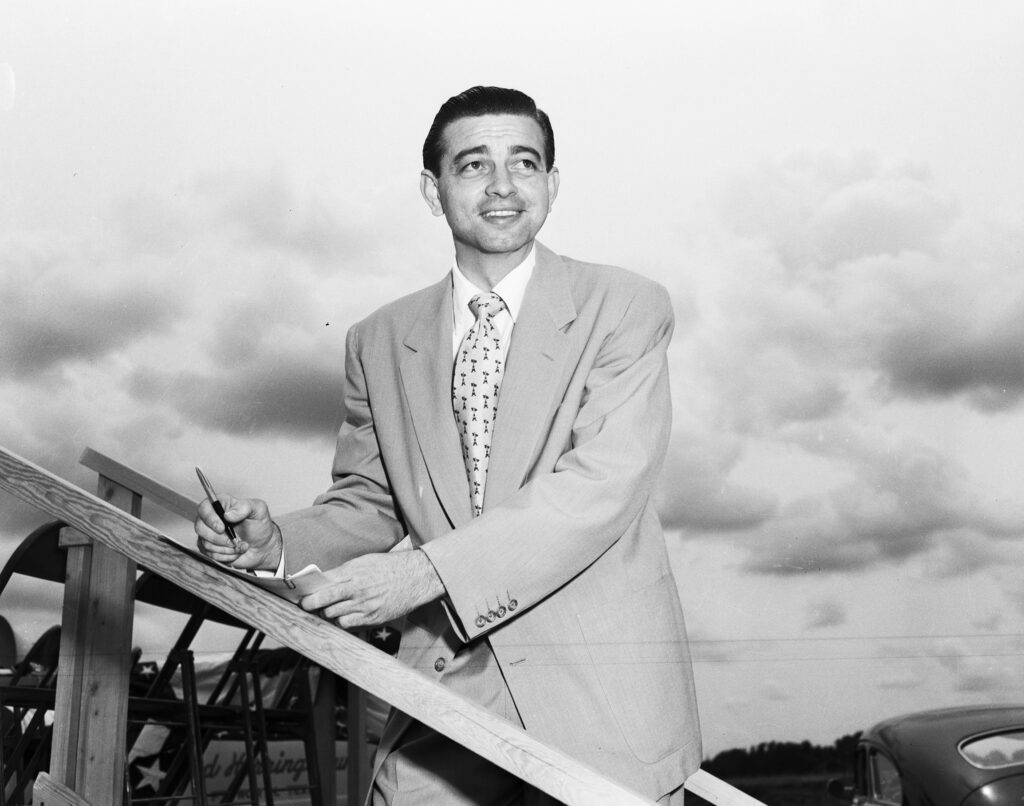 Arlington Mayor Tom Vandergriff standing on a set of stairs to the stage at the groundbreaking ceremony for the General Motors plant to be constructed in Arlington, Texas.