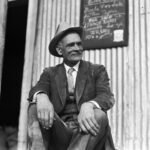 Mayor W. L. Barrett sitting outside building.