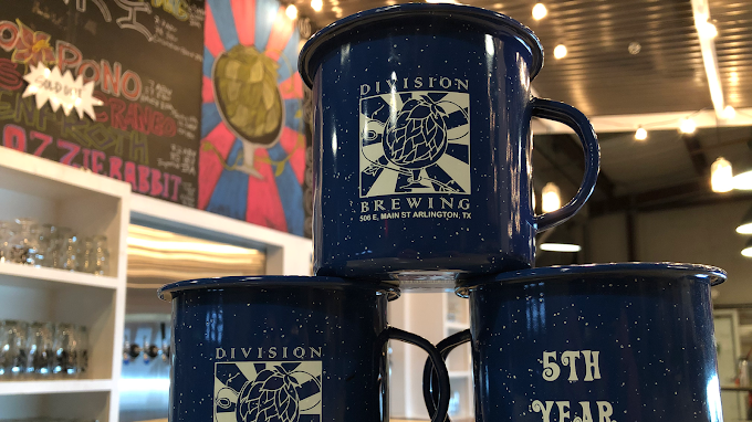 Two mugs supporting one mug with Division Brewing labeled on it.