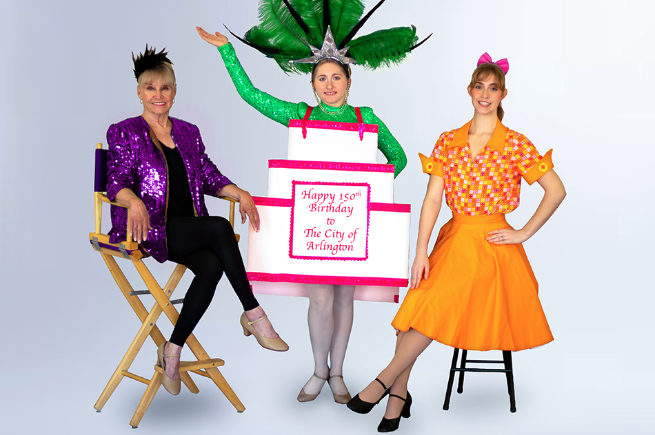 Two women sitting and a women with a birthday cake that says 