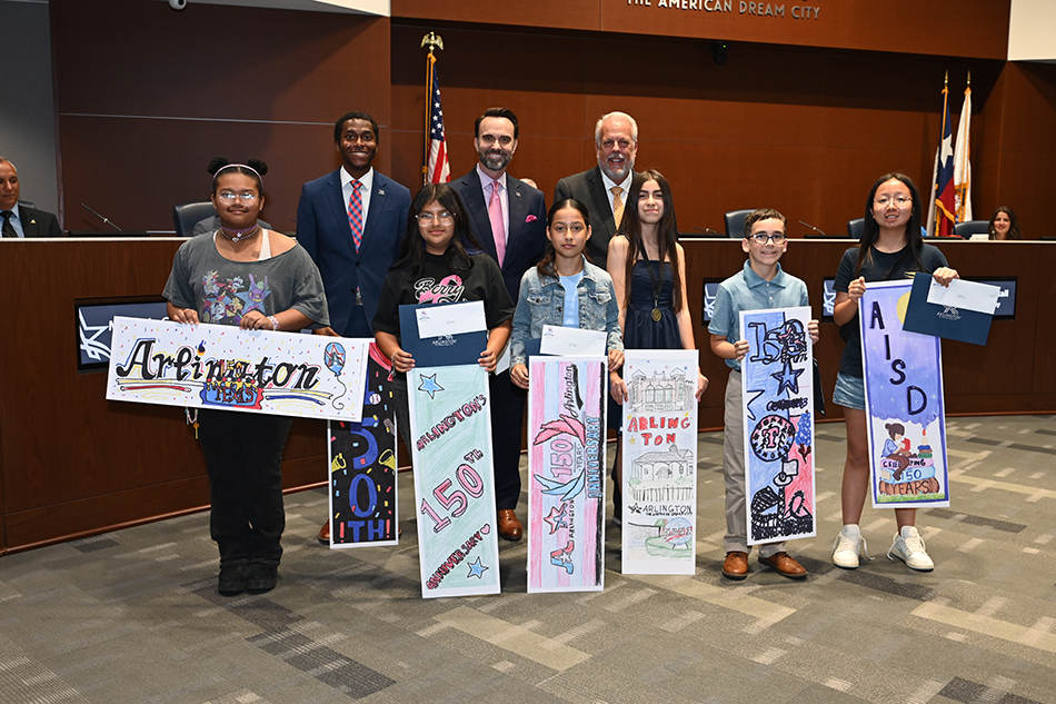 Sixth grade students from AISD hold up bookmark displays and smile for photo after winning a contest.