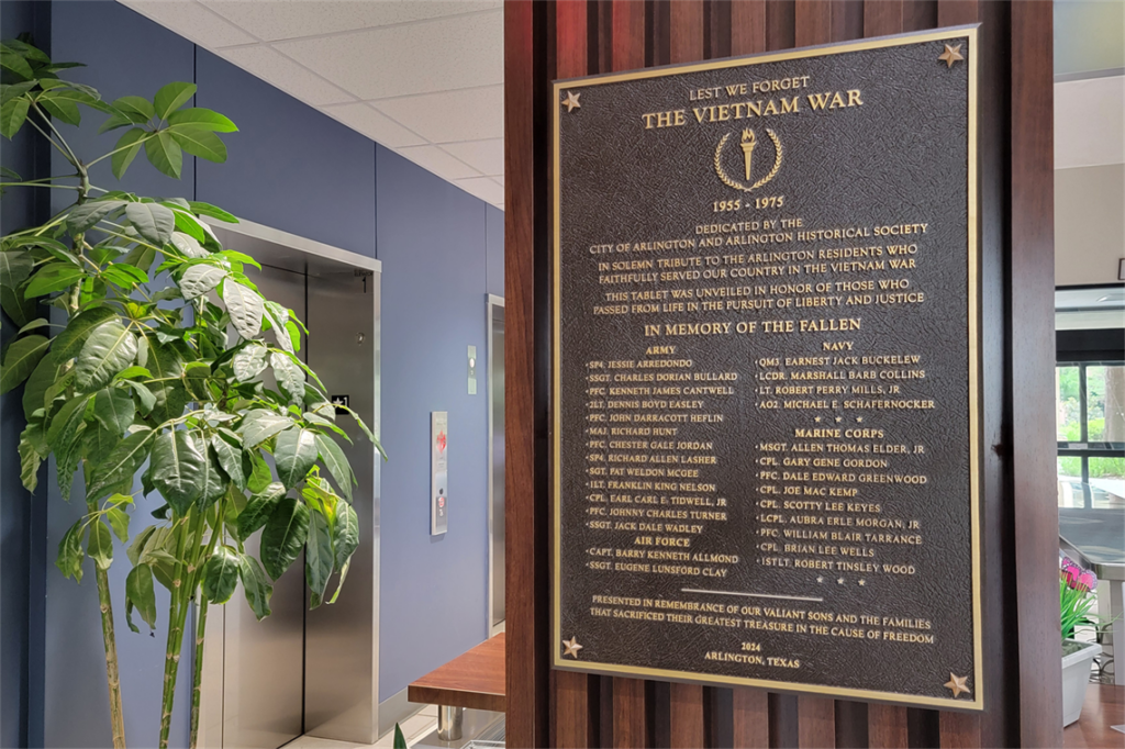Plaque with names of veterans mounted on wall.