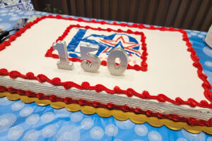 Sheet cake with Arlington 150 logo on it with candles.