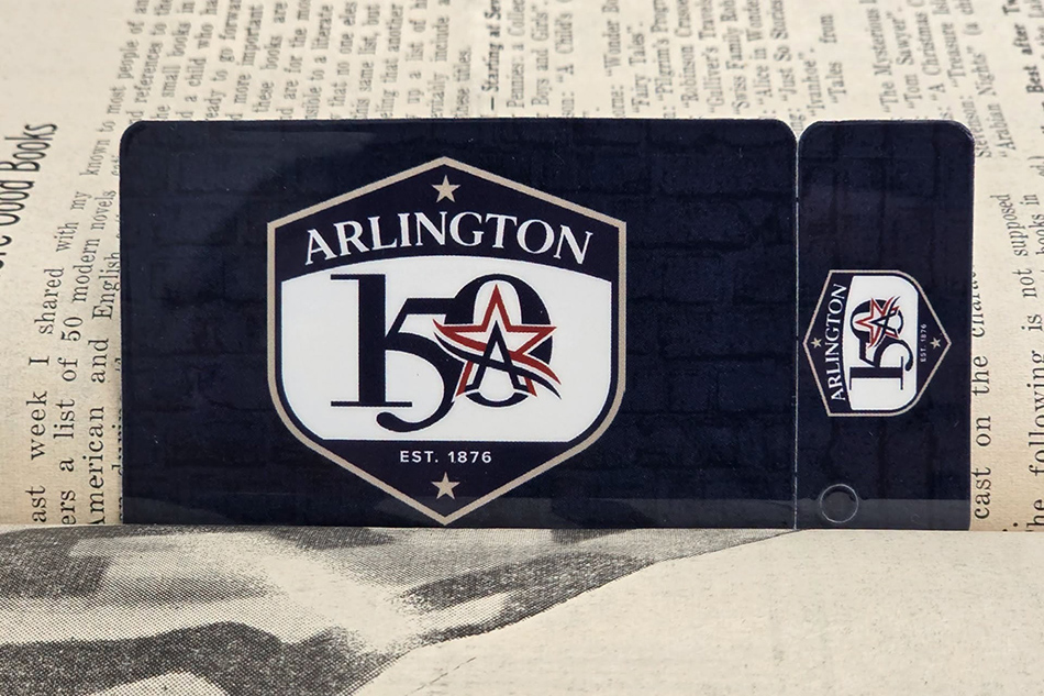 A special edition Arlington Library Card with the City of Arlington's sesquicentennial badge in a book.