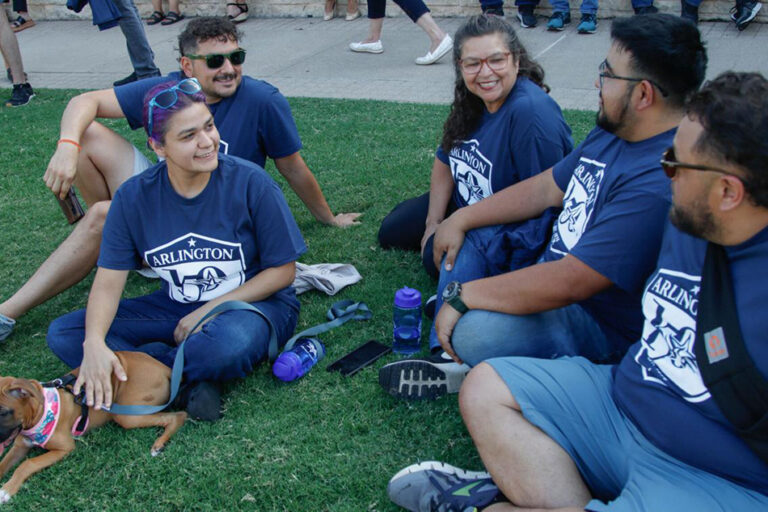 People sitting on lawn talking and smiling.